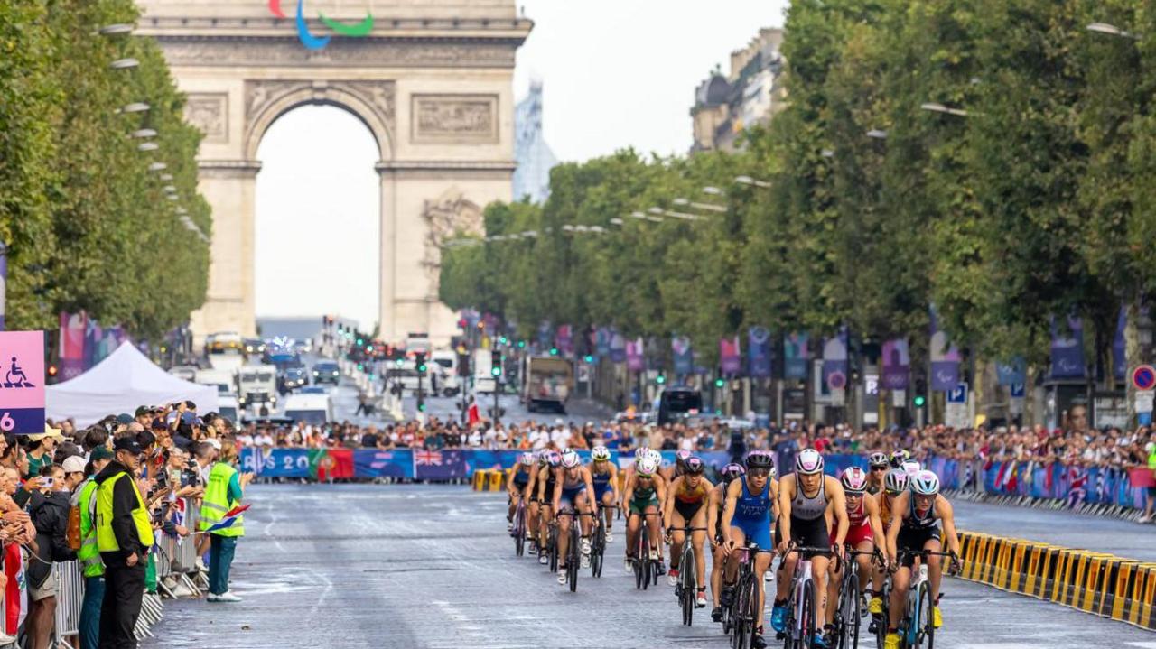 Olympic cyclists on the Champs Elysee in Paris with the Arc de Triomphe in the background