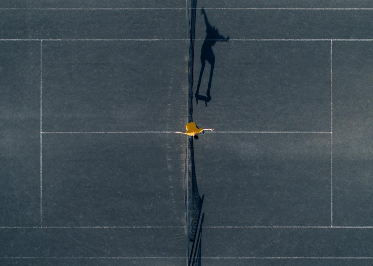 Petra Leary is an award winning New Zealand born aerial photographer. Petra has been up high well before drones and has worked at her aerial photography style for many years. This photo shows a skateboarder jumping over a net on a concrete tennis court