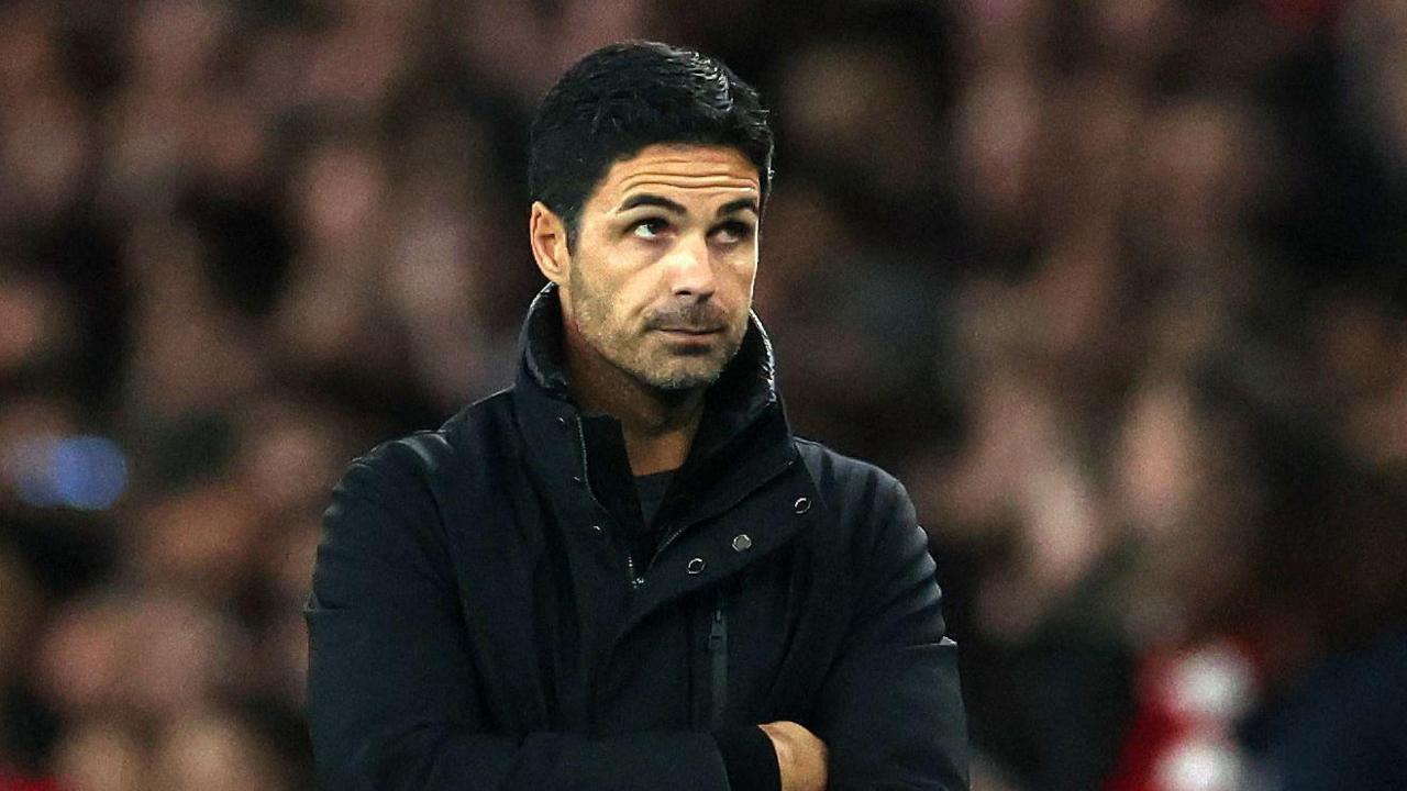 Mikel Arteta stands on the touchline in a dark coat