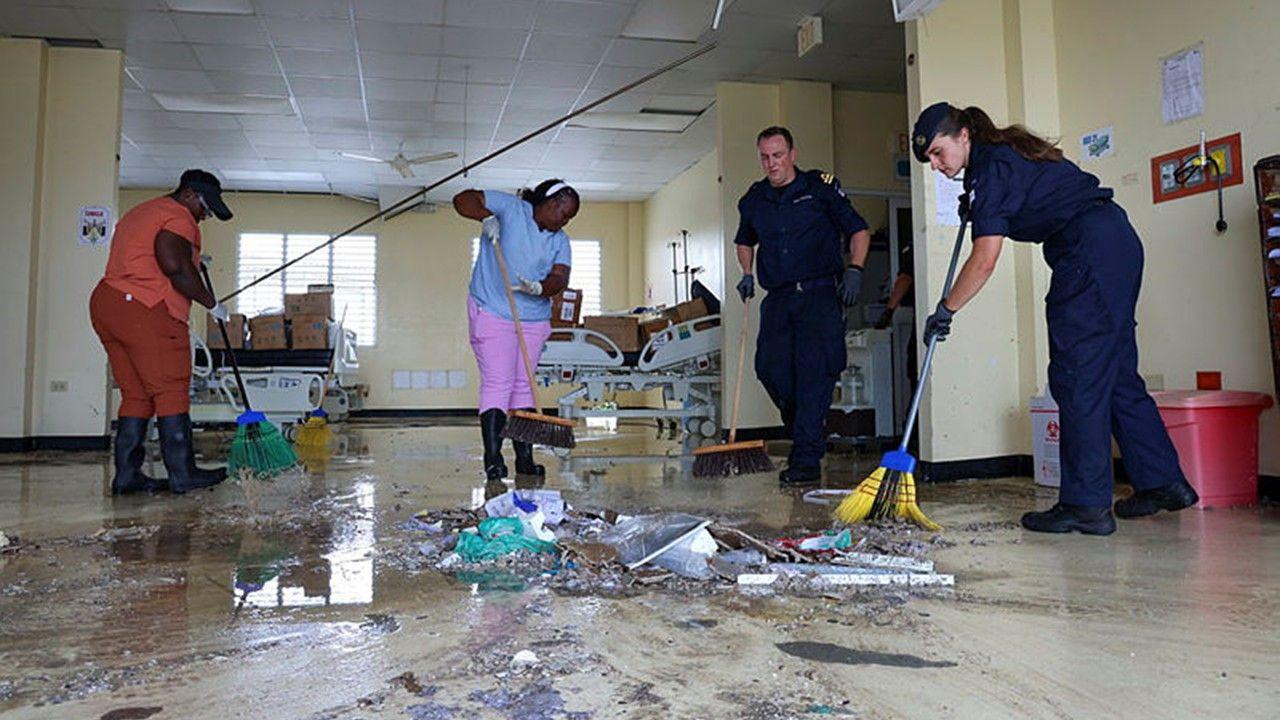Volunteers and members of the Royal Navy sweep debris inside hospital