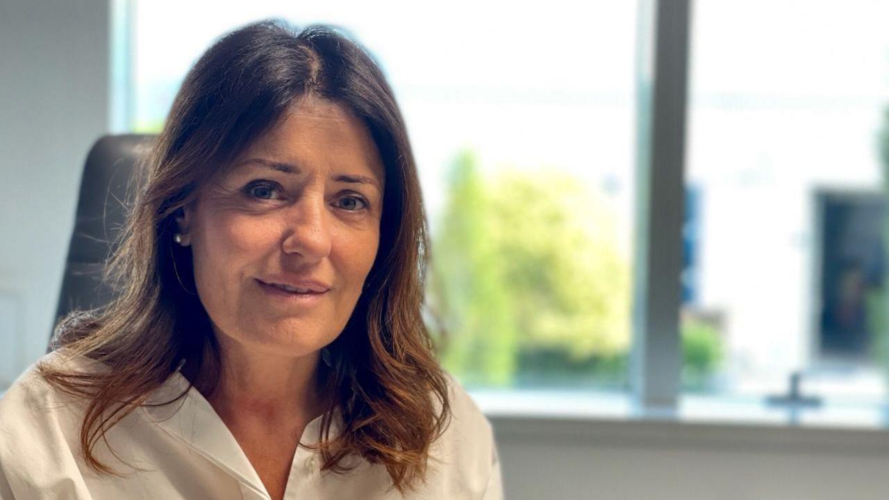 Katia da Ros, a woman with dark hair in a white shirt