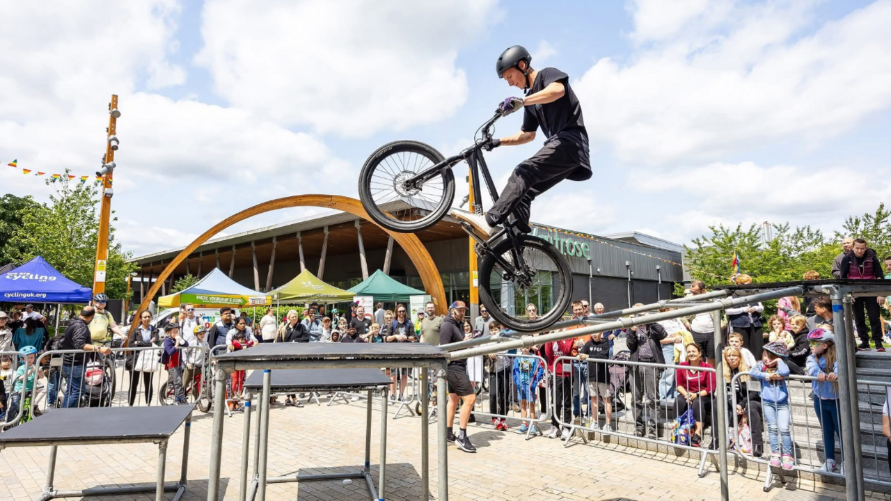 A mountain bike rider pulls a tricks in front of crowds