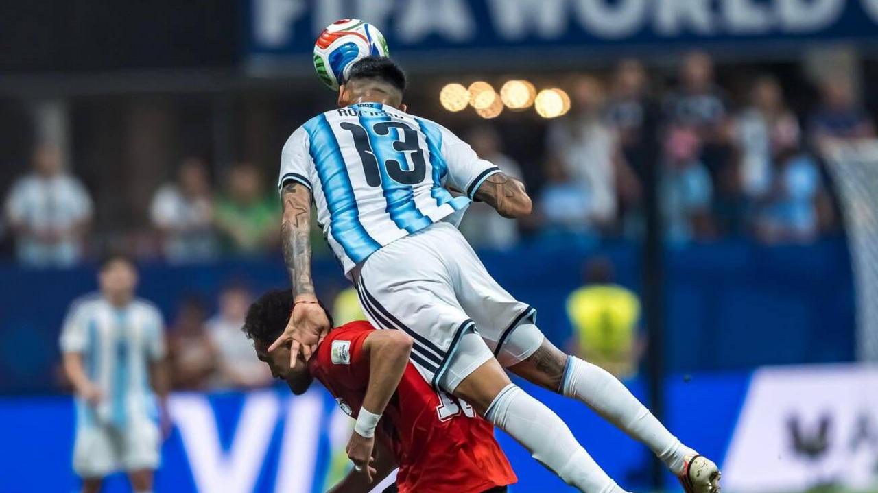 Cristian Romero salta por encima de un delantero egipcio para despejar el balón con un cabezazo en plancha.