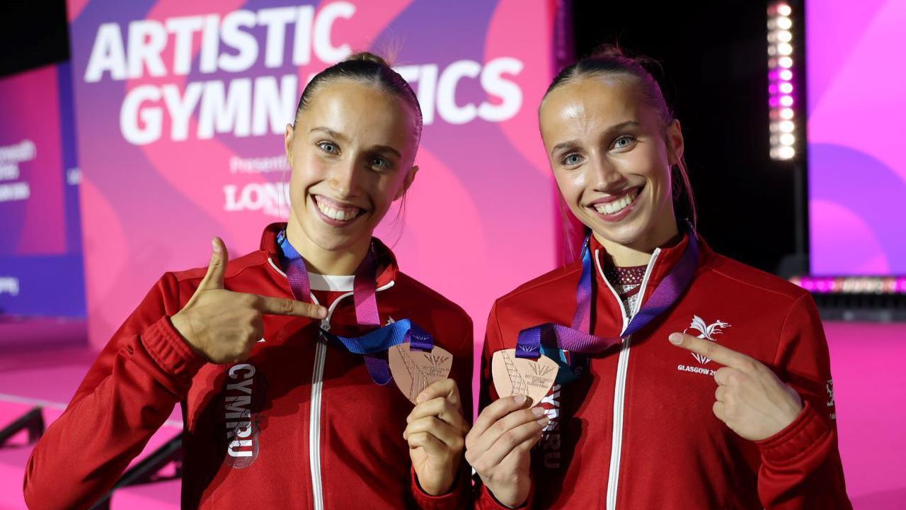 Abigail Roper and Emily Roper celebrate together with medals