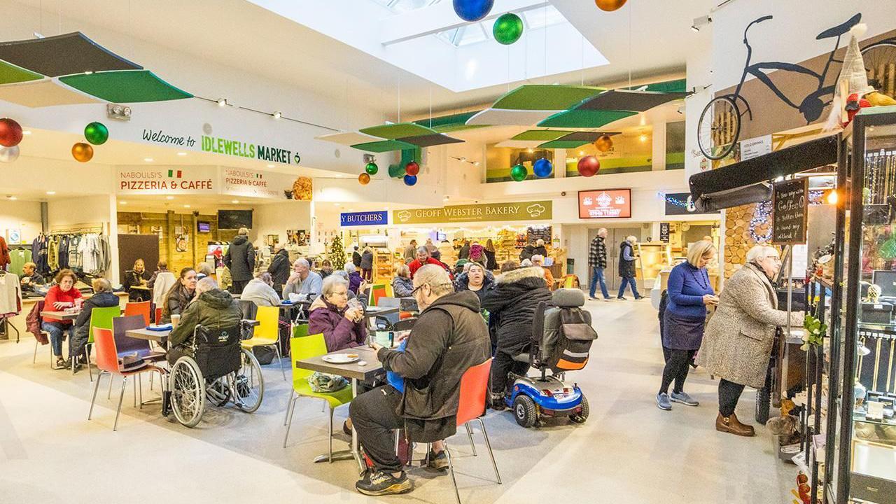 A group of customers sat drinking and eating in the Idelwells indoor market.