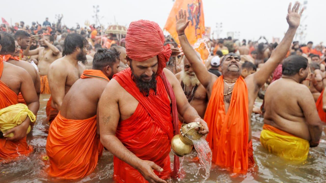 Holy men in saffron robes seen taking a dip in the river