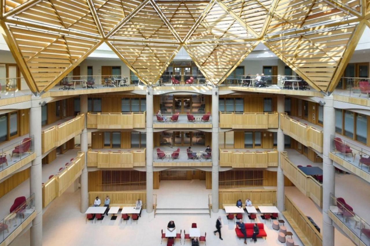 A large hall with three levels above it and a golden petal-like installation in the roof.