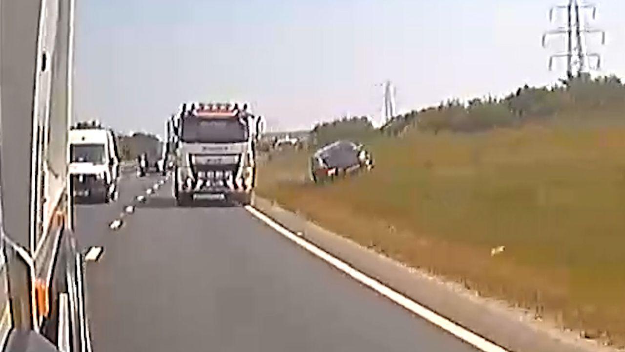 A dashcam image showing a car mounting a grass verge off a dual carriageway. 