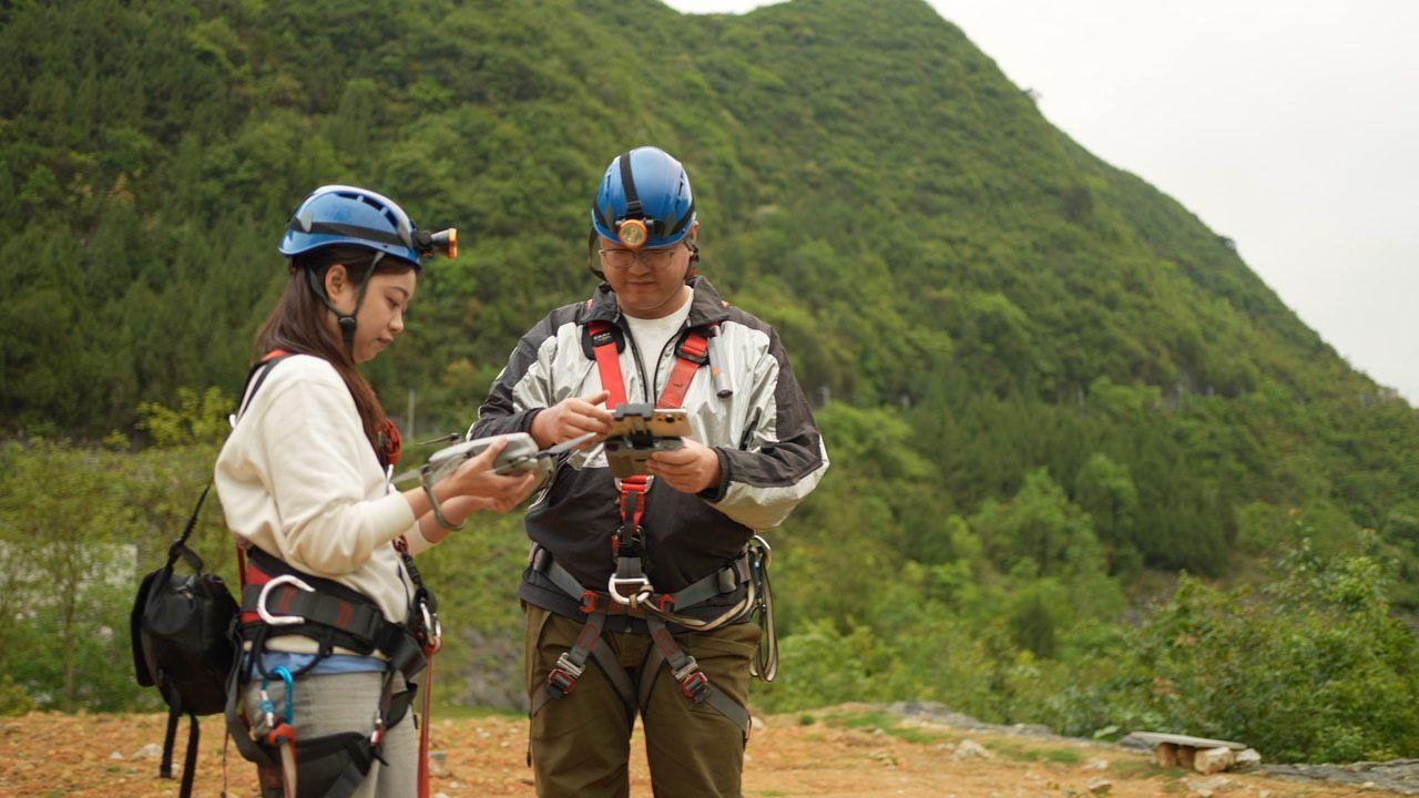 Rui and Michael in full gear, with blue helmets, prepare for their trek into the sinkhole  