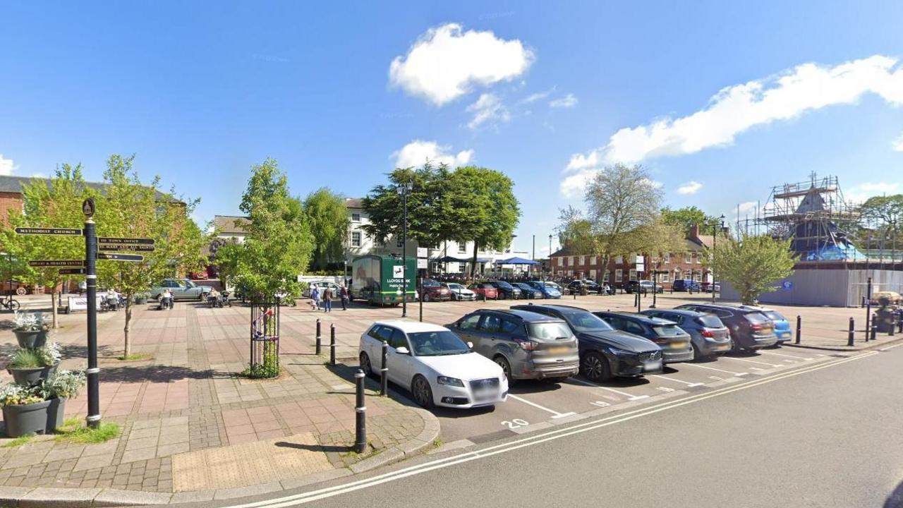 Cars parked around Bingham Market Place on a bright, sunny day