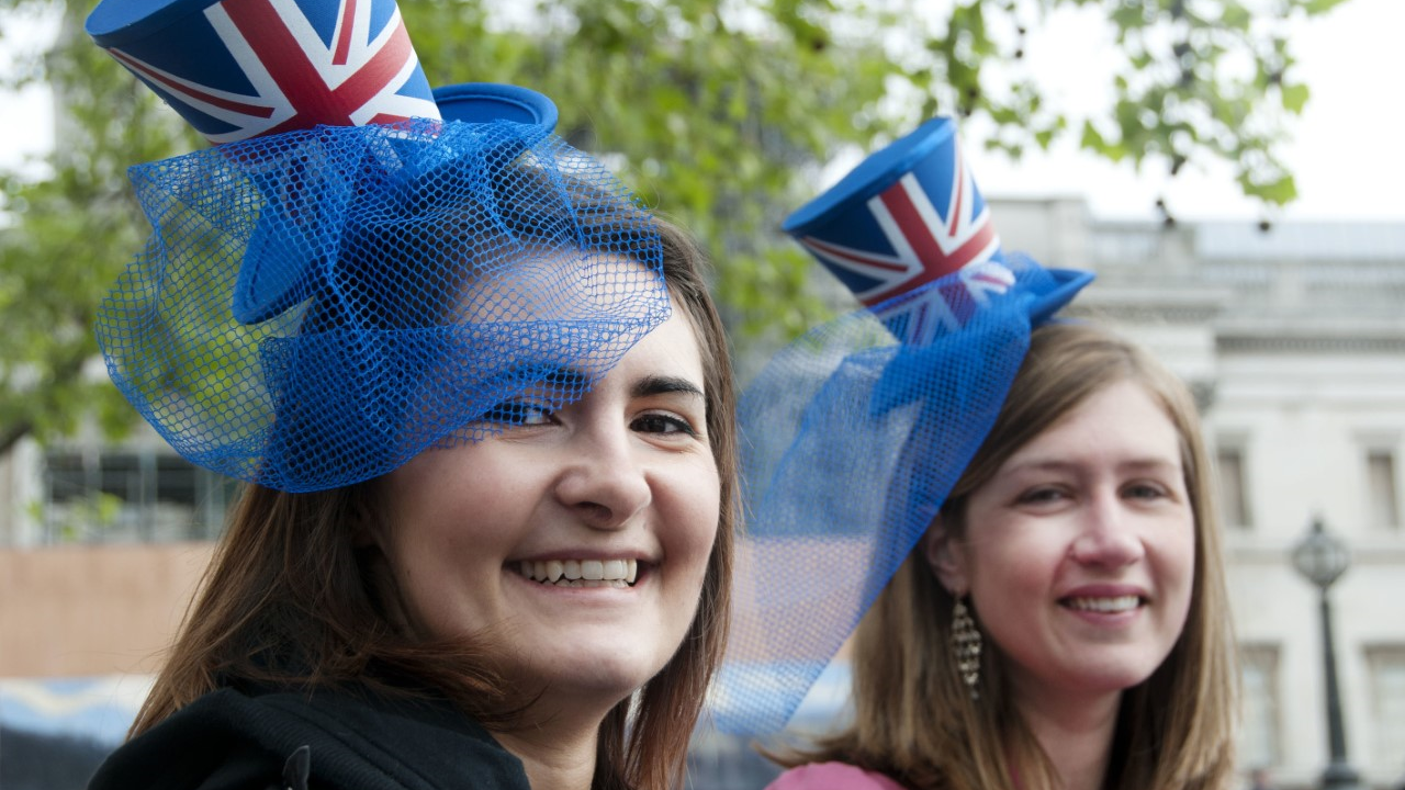 Two young women wear tiny top hat Union Jack fascinators