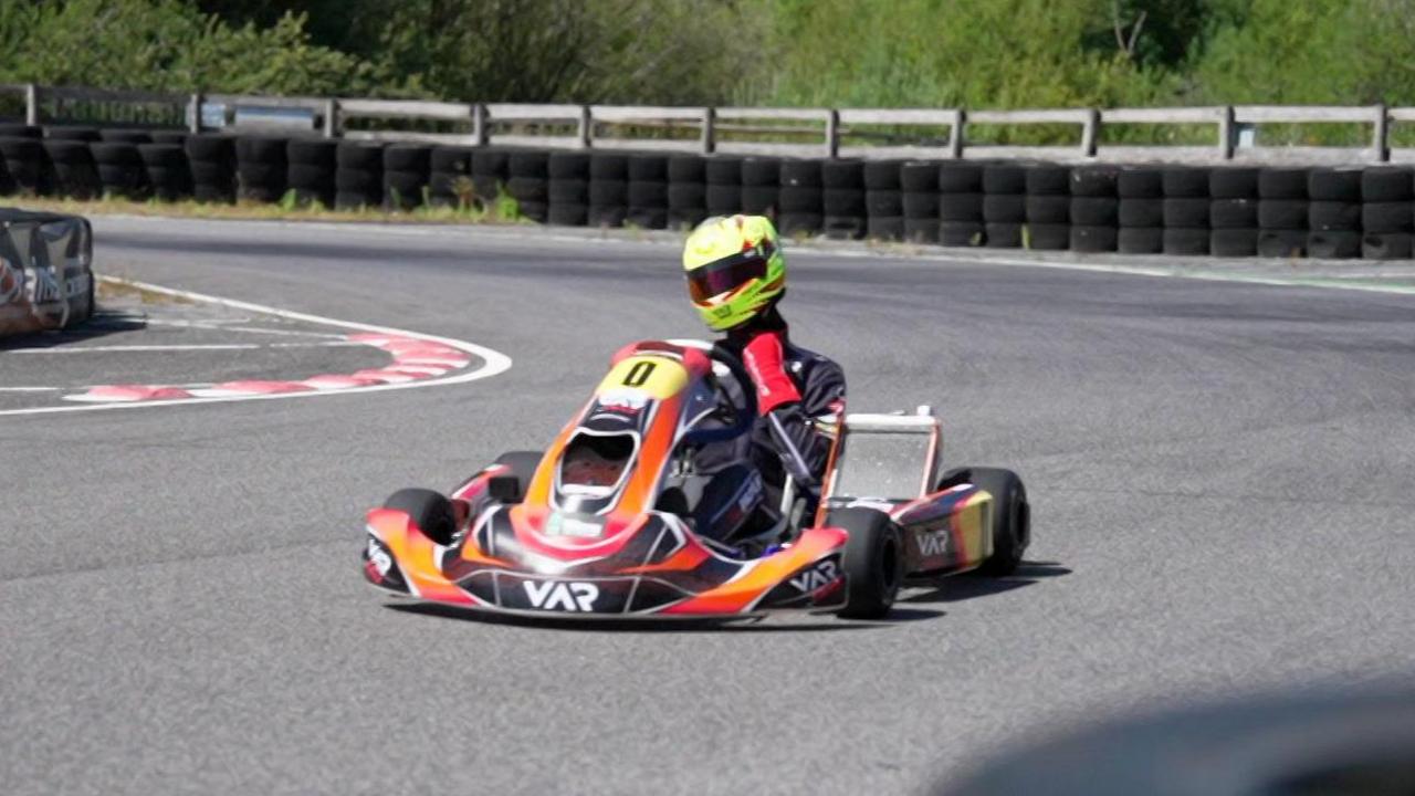 Noah drives his kart round the bend of a race track.