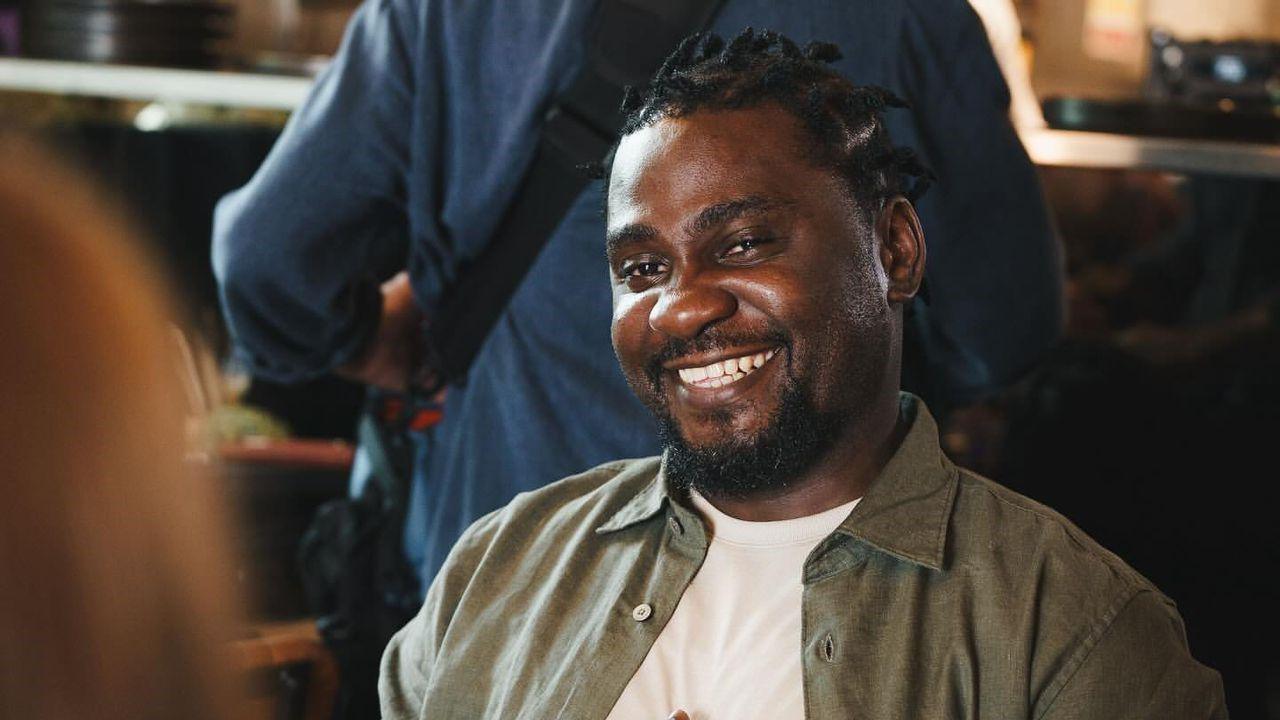 Mr Awobona, wearing a green shirt over a white top, smiling