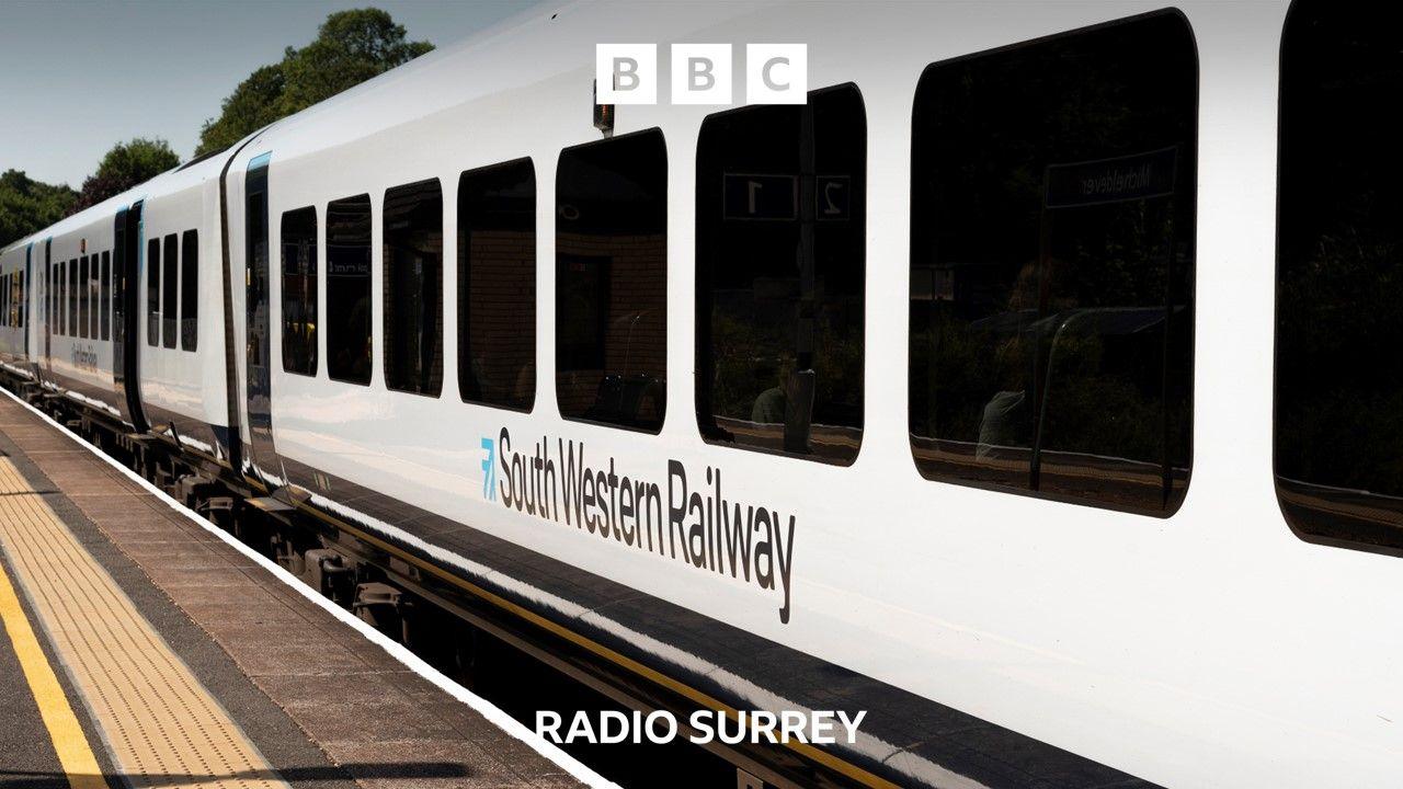 A close up of a white South Western Railway train carriage waiting at a station platform.