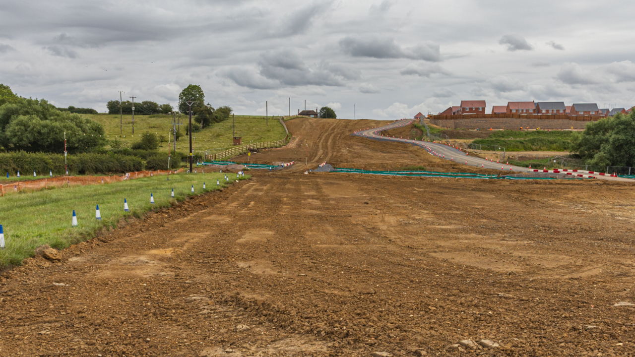 A road construction site with a long area of flattened earth