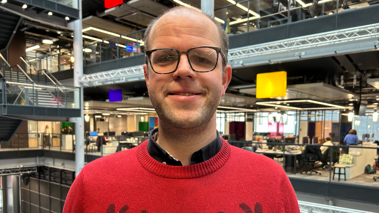 Rhys Griffiths mewn sbectol a siwmper coch