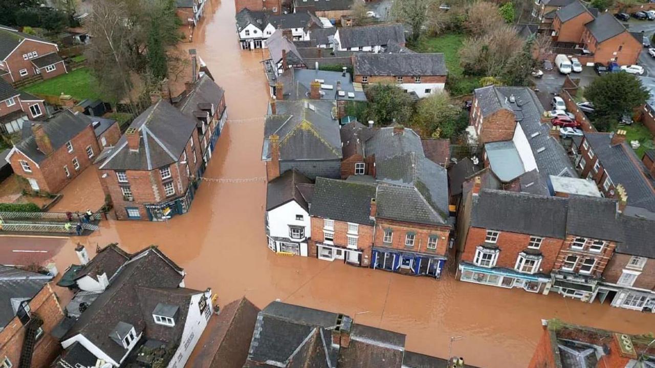 A drone shot of Tenbury Wells which shows brown floodwater along the two of its main streets