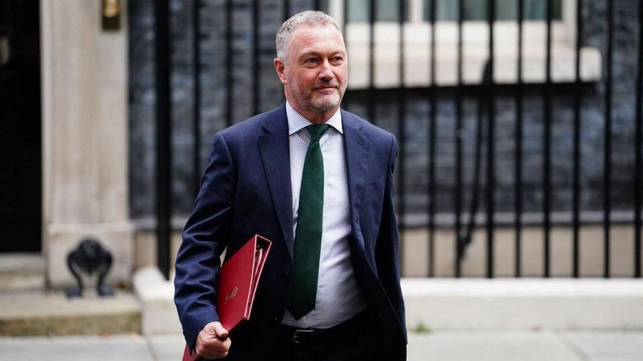 Secretary of State for Environment, Food and Rural Affairs Steve Reed outside No 10 Downing Street wearing a navy suit and carrying a red folder.