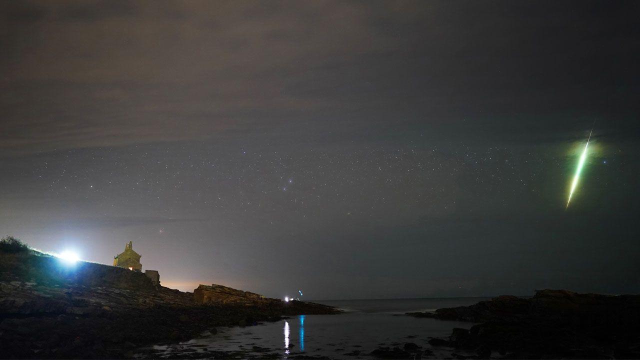 a meteor during the Draconid meteor shower over Howick rocks in Northumberland in 2021