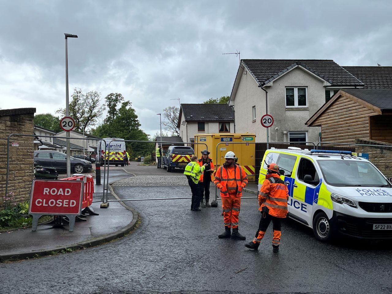 Police and workers in high-vis outside a closed-off street