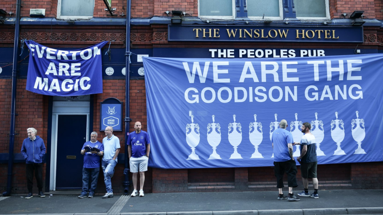 A pub near Goodison adorned in flags, with fans standing nearby