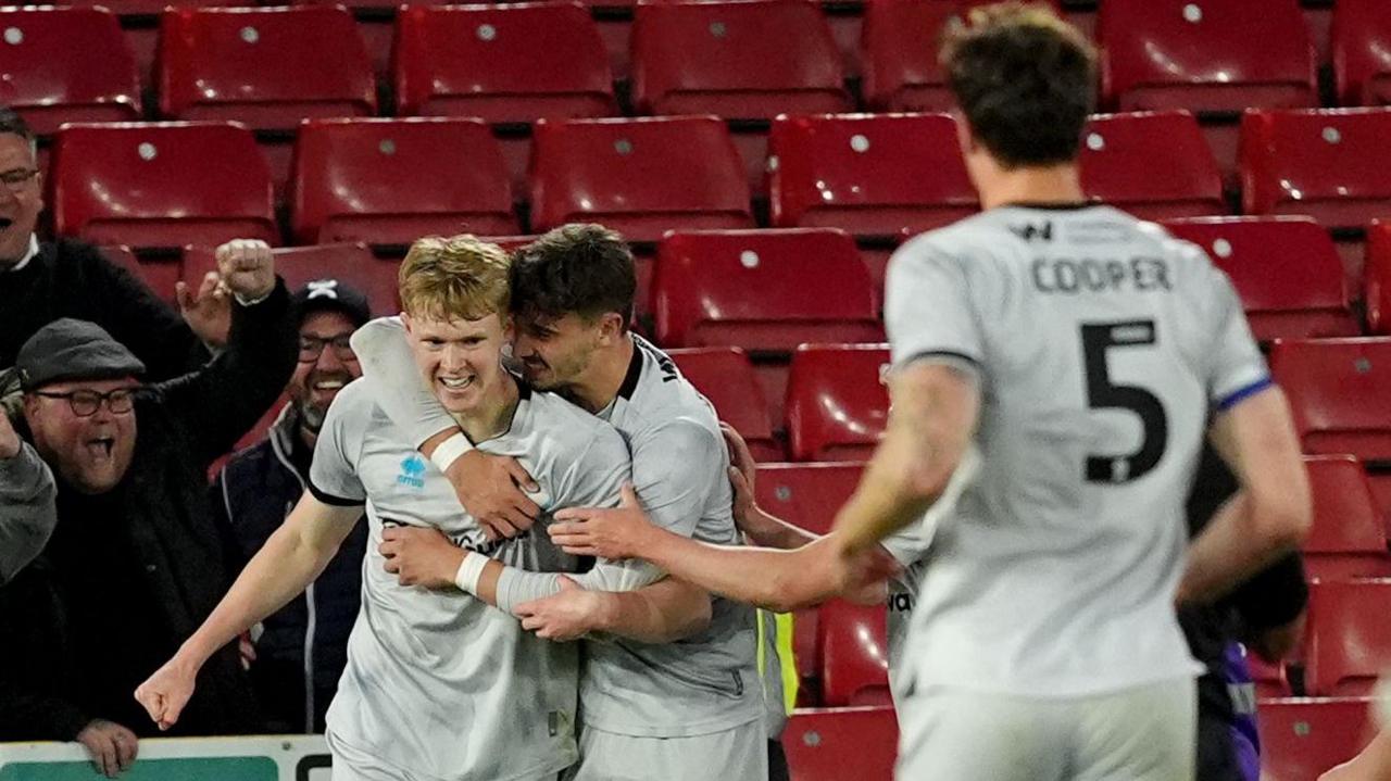 Josh Coburn [left] is congratulated by Luke Cundle [centre] after scoring for Millwall against Sheffield United