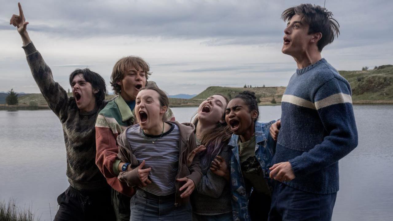 Bella Ramsey and wider cast on set of Sunny Dancer. Group are screaming and cheering in front of a lake