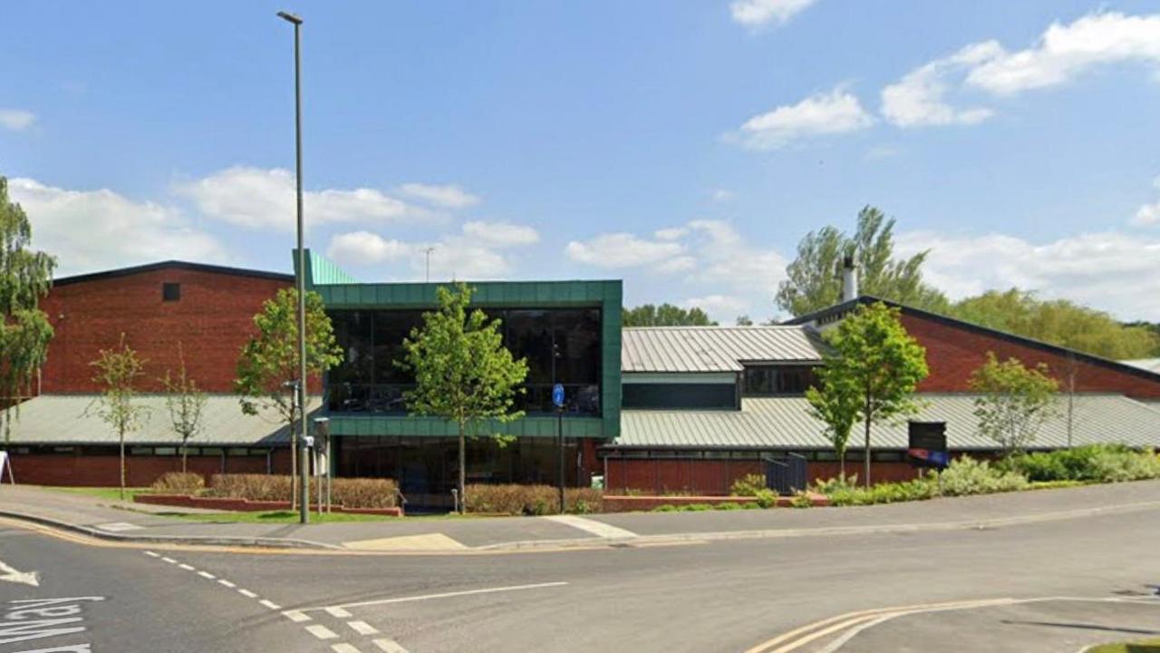 Farnham leisure centre. It is a brown building by a roadside, the sky is blue