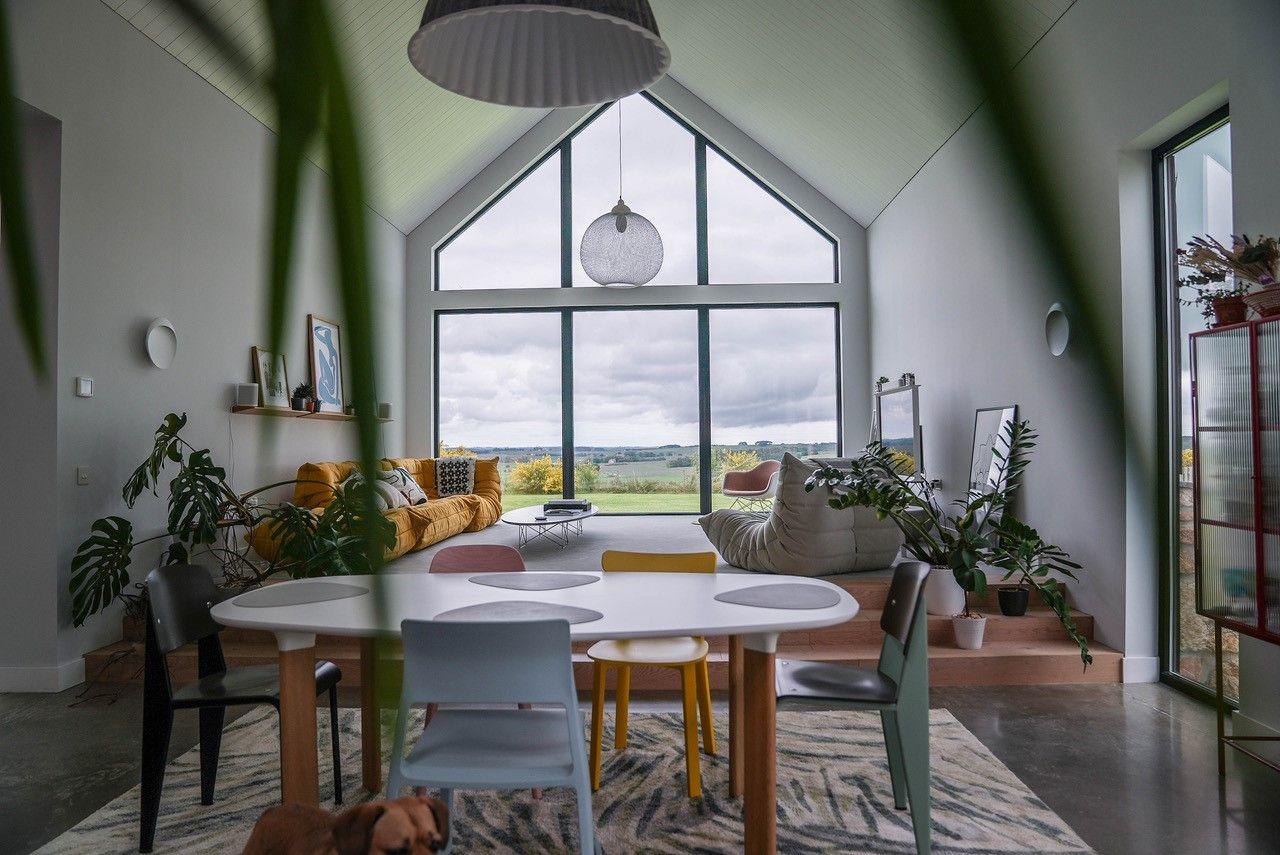 We look from the kitchen through to the double height window and a beautiful view of the green fields beyond.