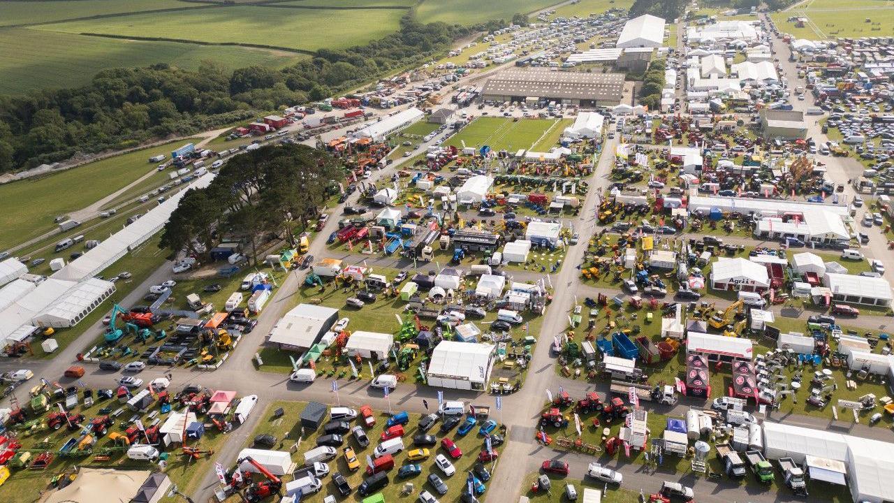 An aerial photo of the showground, showing lots of vehicles on display, and marquees, laid out on grass with concrete paths