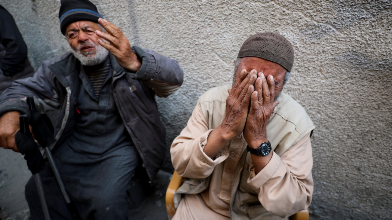 Two elderly Palestinian men react - one holds up his hand, the other holds his head in his hands - at the site of an Israeli strike on a building in Jabalia in northern Gaza