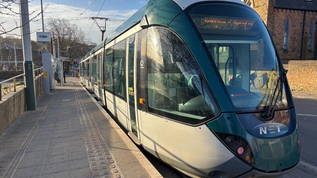 A Nottingham Express Transit tram at a stop in Nottingham