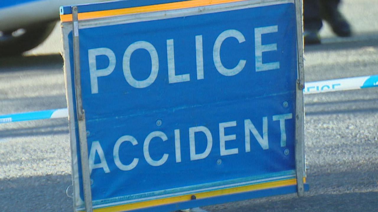 Police accident sign on a road, with bold white letters saying POLICE ACCIDENT on a blue background.