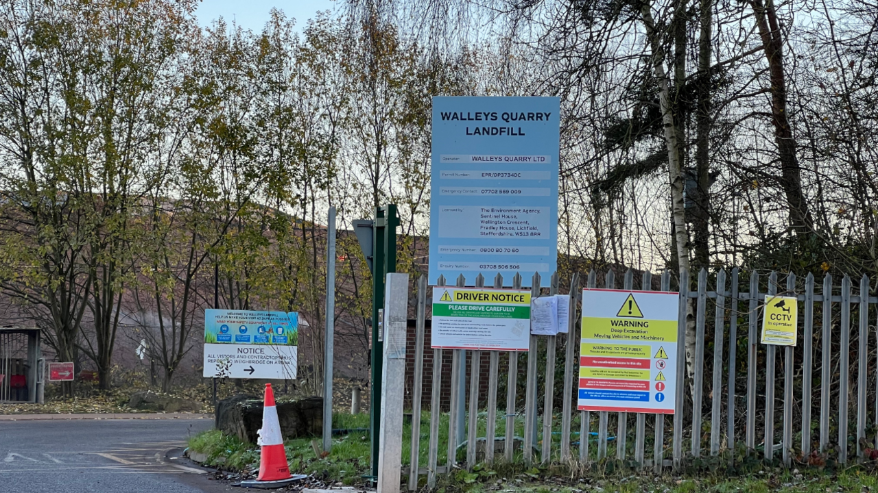 Walleys Quarry entrance, with a metal slatted fence and a sign saying Walleys Quarry Landfill