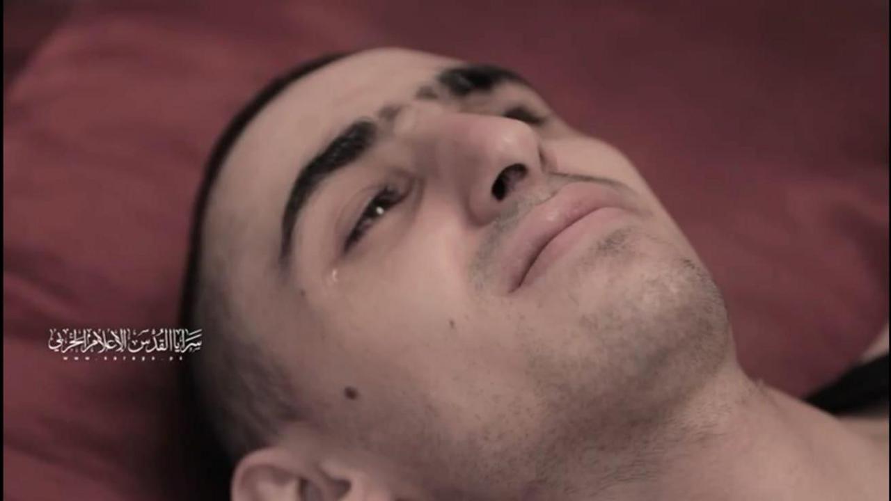 Rom Braslavski lies on the ground, only his head visible, crying