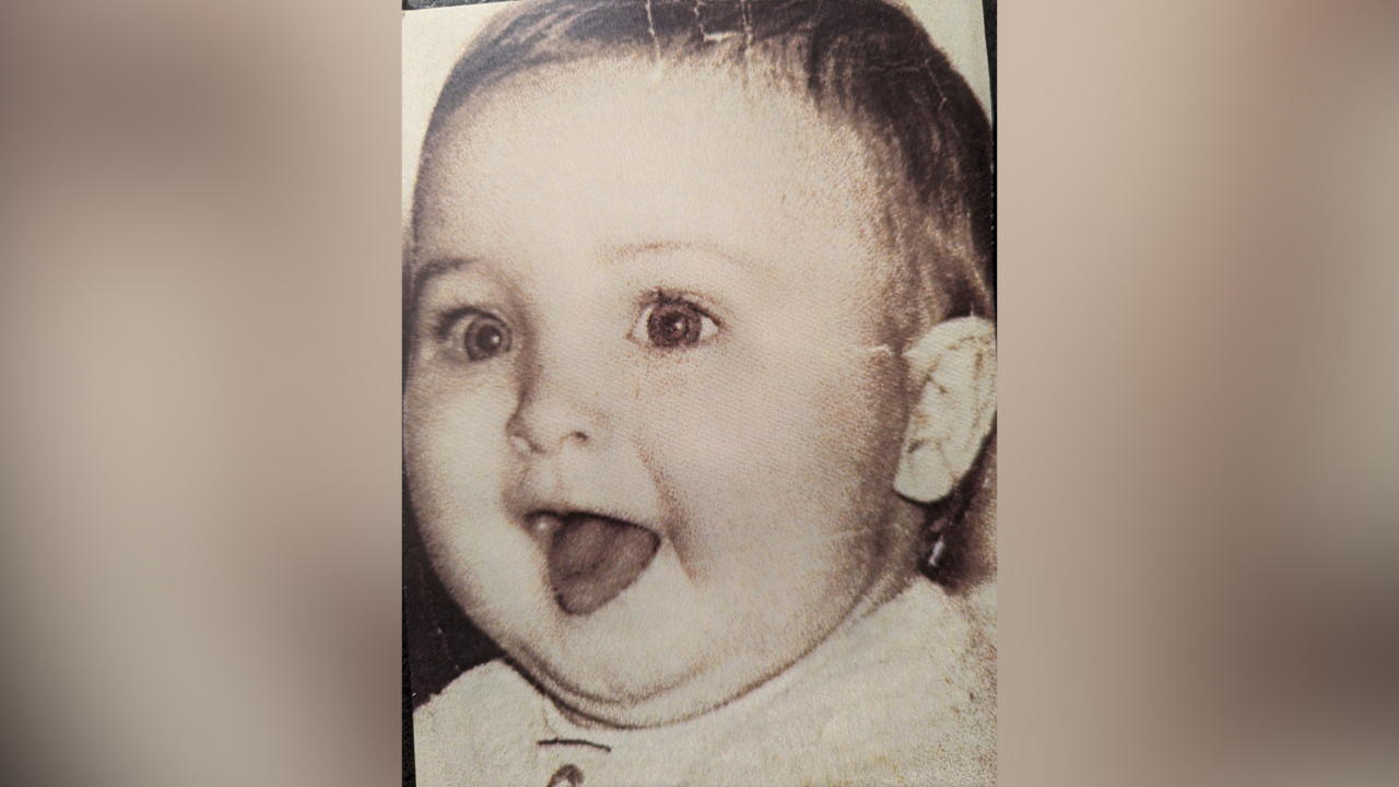 A black and white image of a baby, taken in the 1960s/1970s, sticking his tongue out