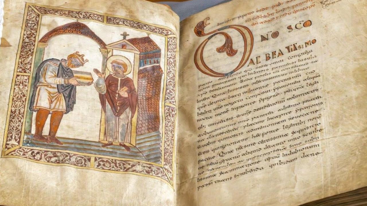 An old book - a manuscript with browning pages is open at a page showing two men on the left and writing on the right