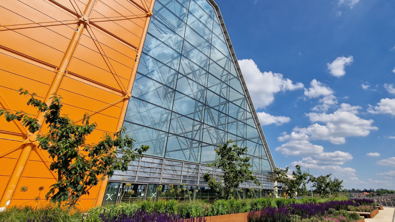 An orange-walled building with a sloped glass-fronted side