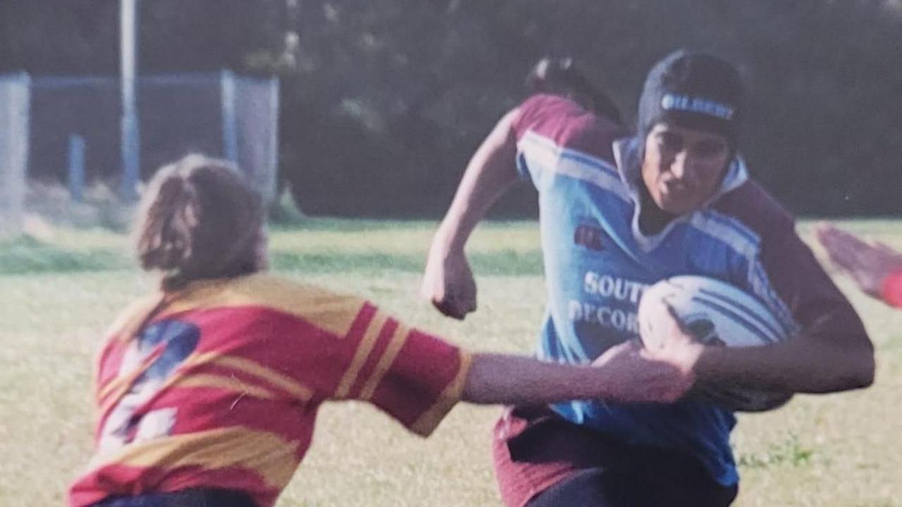 One woman tackling another woman as they run towards the camera with a rugby ball