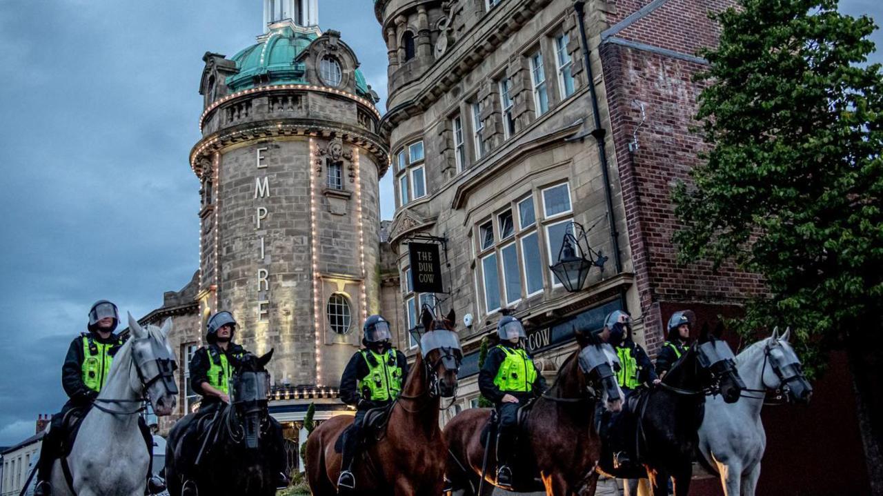 Mounted police officers outside the Sunderland Empire Theatre on 2 August during the riots