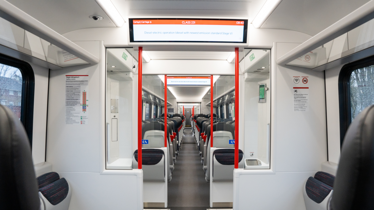 The interior of a South Wales Metro tram train with seats and display screens