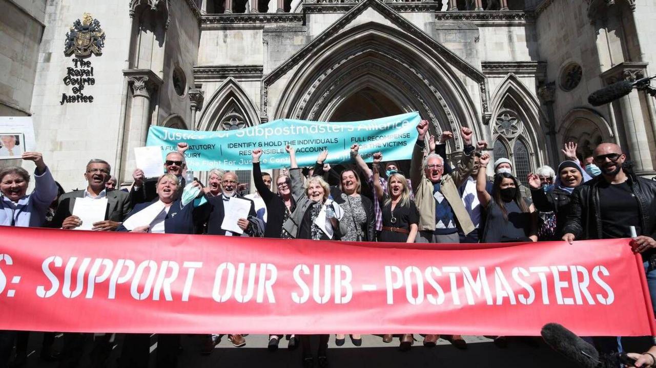 A group of sub-postmasters outside a court
