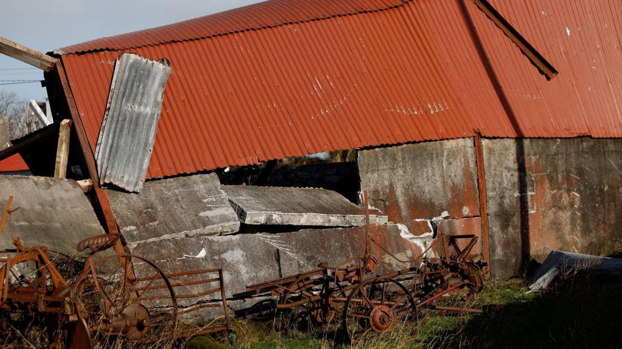 A red roofed barn with a collapsed roof in County Galway 