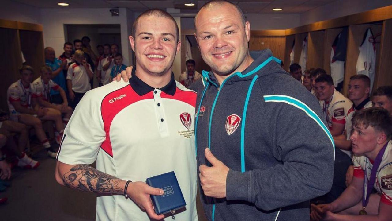 A young Jonah Cunningham stands with his dad Kieron in the changing room at St Helens