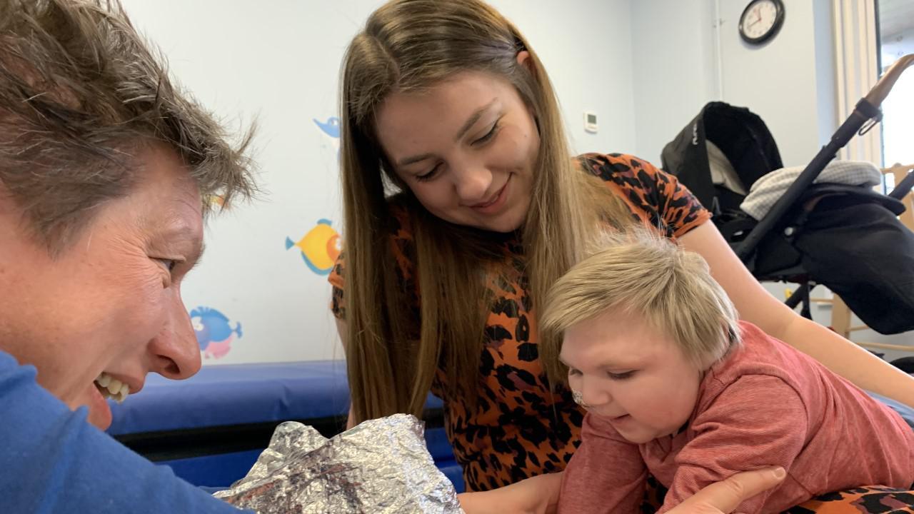 Oakley playing with his mother and a charity worker