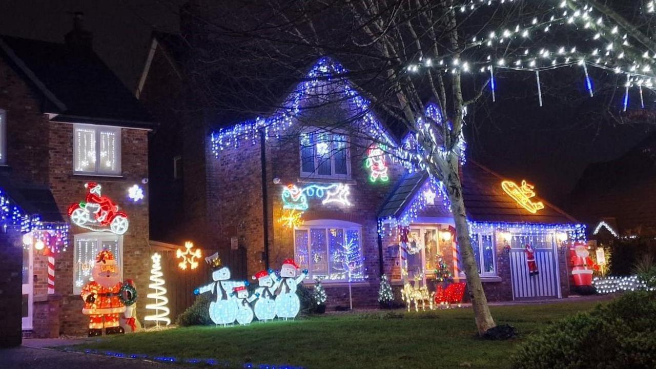 Two detached houses with large Christmas displays including snowmen, Father Christmas, reindeers and icicles.
