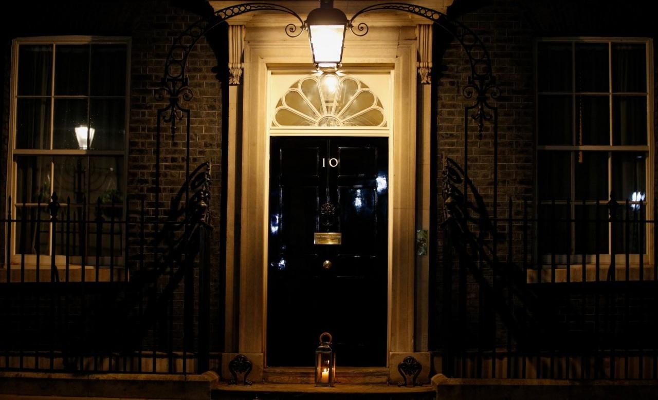 A candle burns in a remembrance lantern placed outside the door of 10 Downing Street.