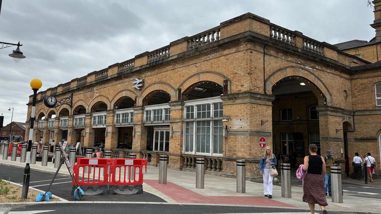 York Railway Station. It is a large square brick building with arches and white-framed windows at the front.