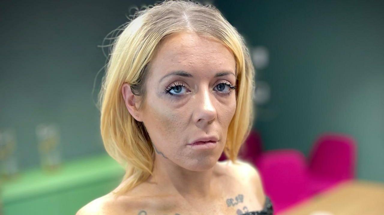 Courtney Smith, she has a blonde bob and is wearing a black dress