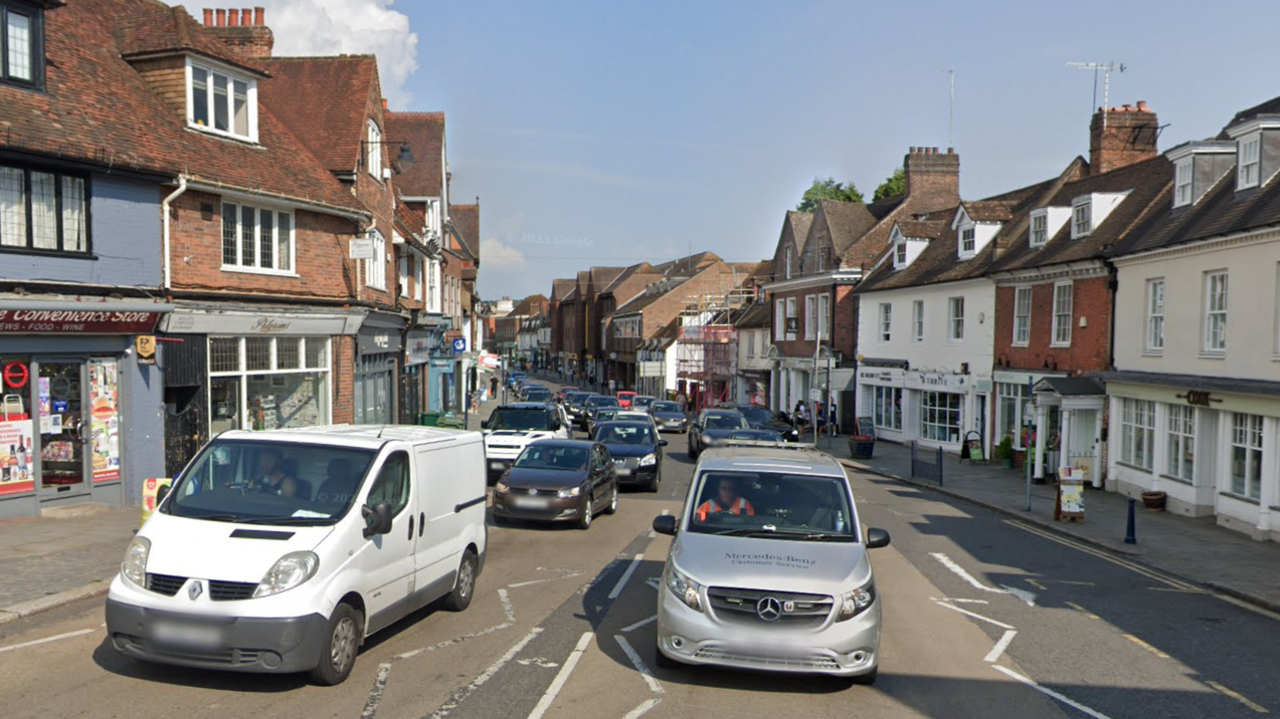 Reigate High Street - a street filled with cars and lined with retail units.